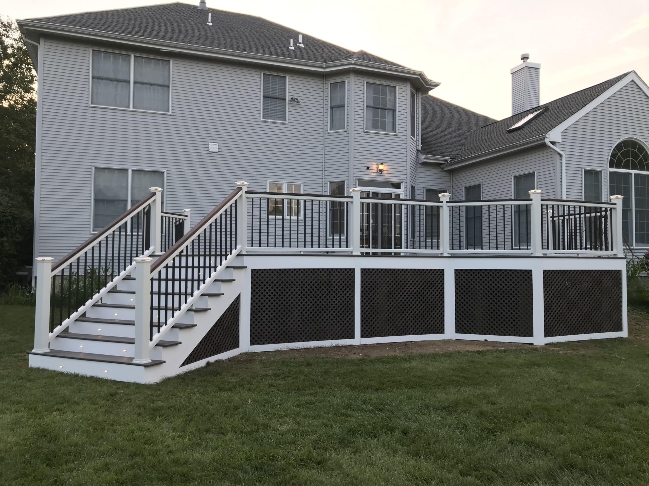 Back of a home's wooden deck with custom lighting design on the stairs