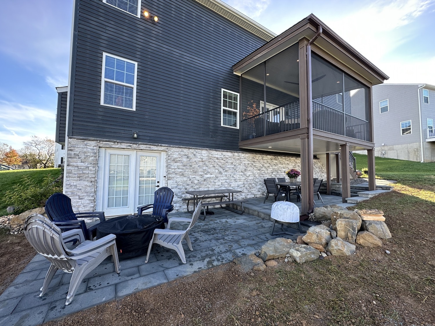 A home with a rear deck that has stairs with lighting